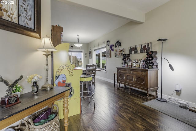 corridor featuring beamed ceiling, wood finished floors, and baseboards