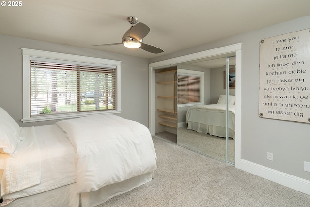 carpeted bedroom featuring a closet, baseboards, and a ceiling fan