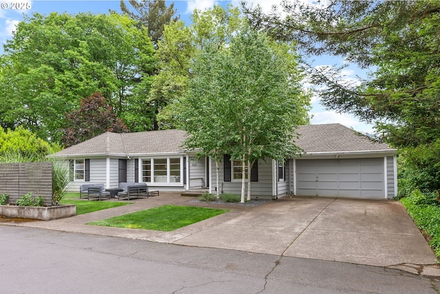 single story home featuring a garage, driveway, a shingled roof, and fence