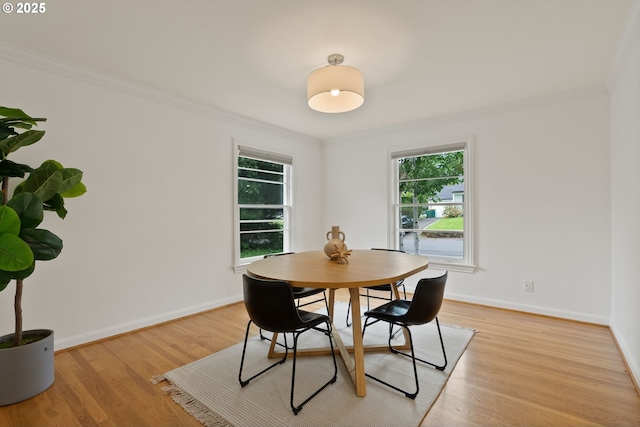 dining room featuring ornamental molding, baseboards, and light wood-type flooring