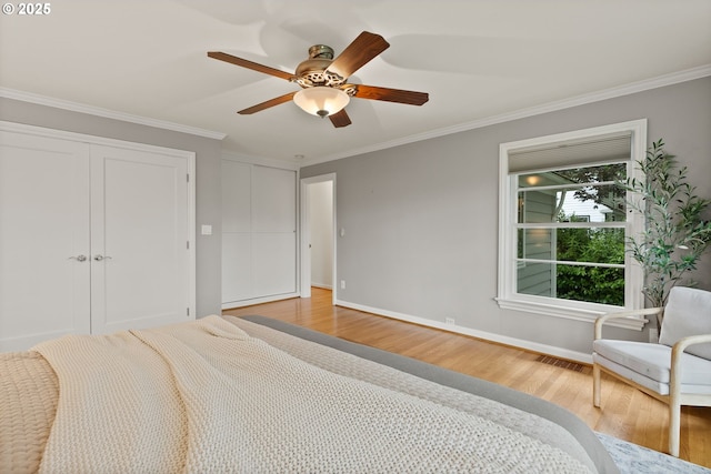 bedroom featuring wood finished floors, ornamental molding, baseboards, and ceiling fan