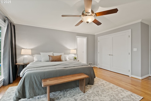 bedroom featuring light wood-style flooring, ornamental molding, baseboards, and ceiling fan