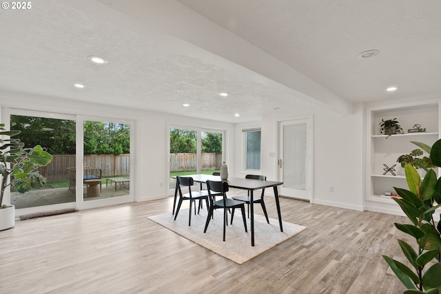 dining room with light wood-style floors, baseboards, recessed lighting, built in features, and a textured ceiling