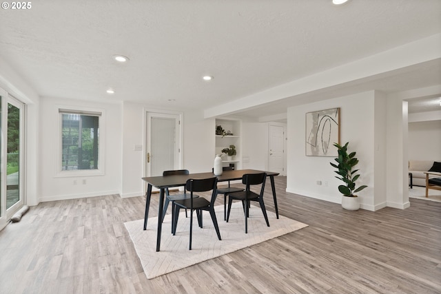 dining area featuring light wood-style floors, baseboards, recessed lighting, and a textured ceiling