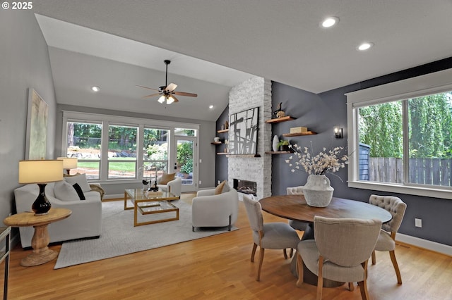 850 NW 114th Ave, Portland, OR 97229 - dining space with plenty of natural light, vaulted ceiling, light wood-style floors, a ceiling fan, and a brick fireplace