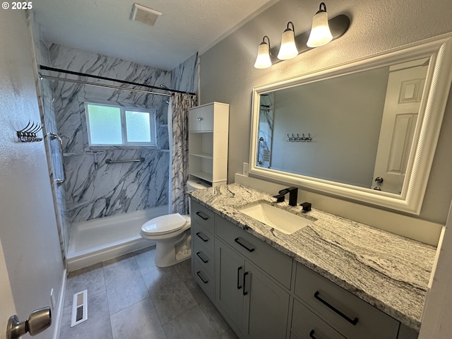 full bath featuring toilet, vanity, visible vents, and a stall shower