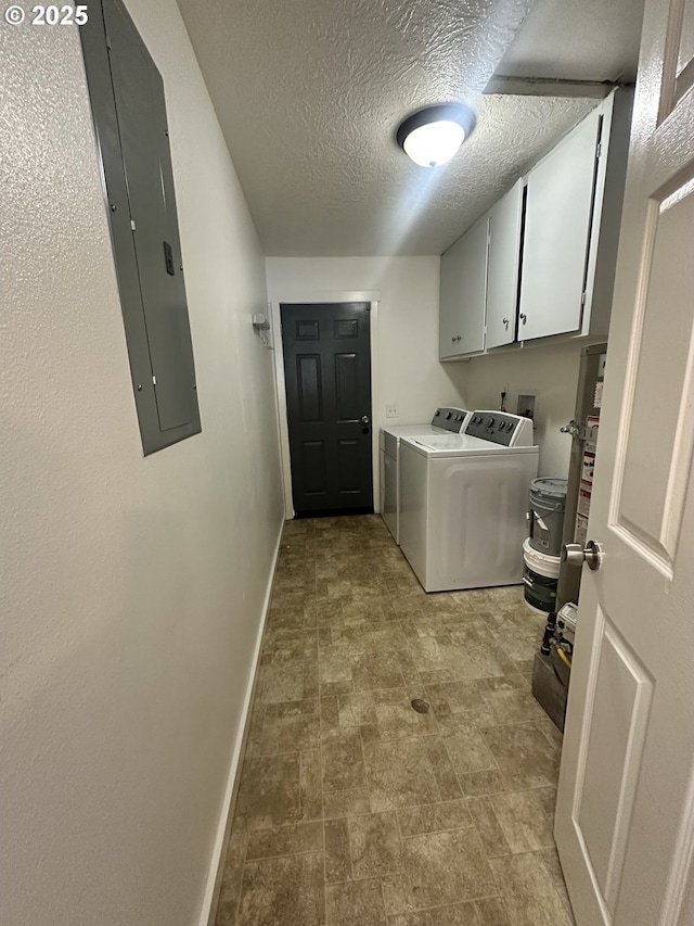 laundry room with washer and clothes dryer, a textured ceiling, electric panel, cabinet space, and baseboards