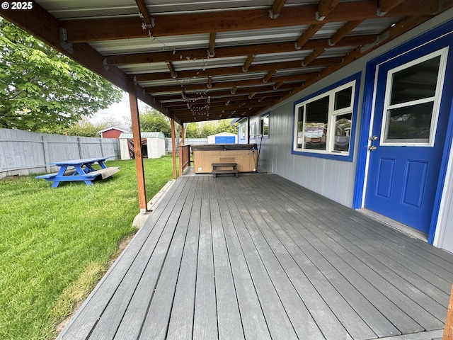 wooden terrace with a lawn, a fenced backyard, and a hot tub
