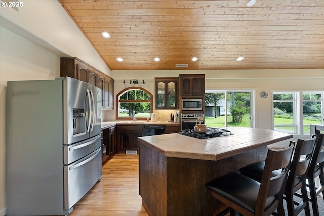 54601 Winterberry Dr, Bandon, OR 97411 - kitchen with black appliances, wooden ceiling, healthy amount of natural light, light wood-style floors, and a kitchen bar