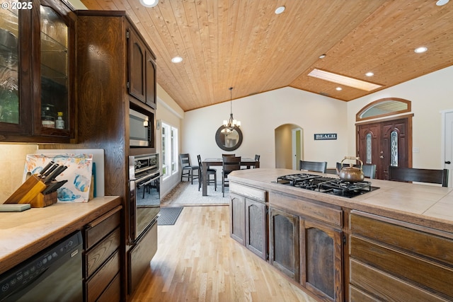 54601 Winterberry Dr, Bandon, OR 97411 - kitchen with black appliances, arched walkways, wood ceiling, light wood-type flooring, and vaulted ceiling