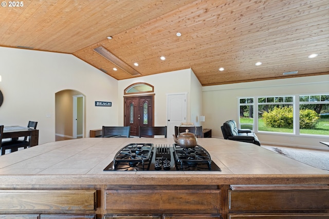 54601 Winterberry Dr, Bandon, OR 97411 - kitchen featuring stovetop with downdraft, tile counters, arched walkways, vaulted ceiling, and wood ceiling