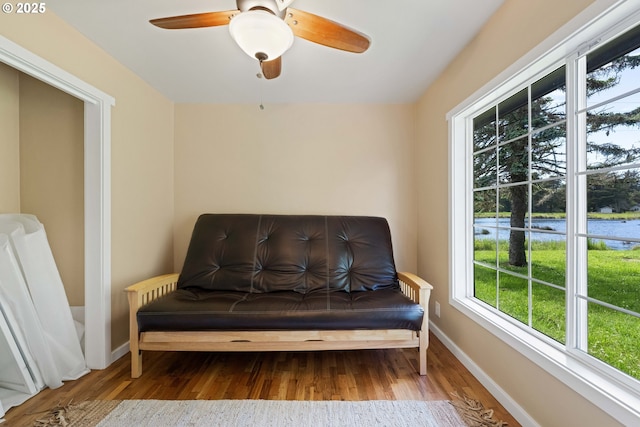 54601 Winterberry Dr, Bandon, OR 97411 - living area with wood finished floors, baseboards, a water view, and ceiling fan