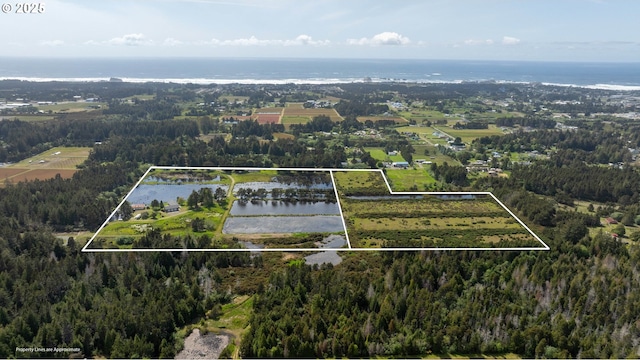 54601 Winterberry Dr, Bandon, OR 97411 - aerial overview of property's location with a nearby body of water, property boundaries highlighted, and a heavily wooded area
