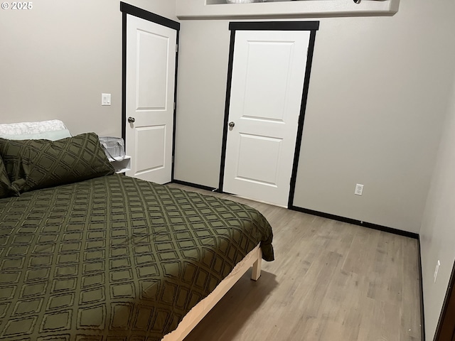 bedroom with baseboards and light wood-style floors