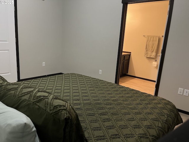 bedroom with baseboards and ensuite bath