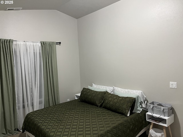 bedroom featuring vaulted ceiling and visible vents