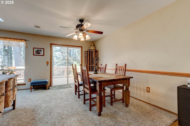 carpeted dining space featuring ceiling fan, baseboards, and a wealth of natural light