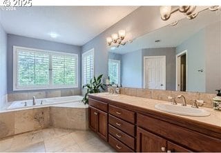 bathroom featuring a notable chandelier, vanity, and tiled bath