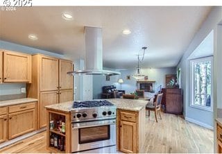 kitchen featuring light countertops, high end range, island exhaust hood, and light wood-style flooring