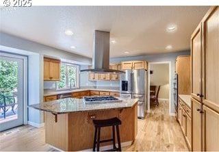 kitchen with a kitchen island, stainless steel appliances, island range hood, and a breakfast bar area