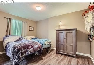 bedroom with baseboards and wood finished floors