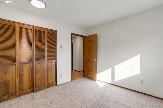 10915 SW Meadowbrook Dr Unit 22, Portland, OR 97224 - unfurnished bedroom featuring light carpet, a closet, and a textured ceiling