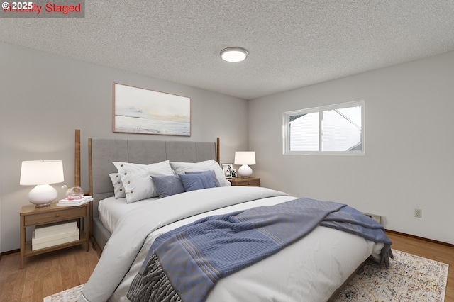 10915 SW Meadowbrook Dr Unit 22, Portland, OR 97224 - bedroom with a textured ceiling and wood finished floors