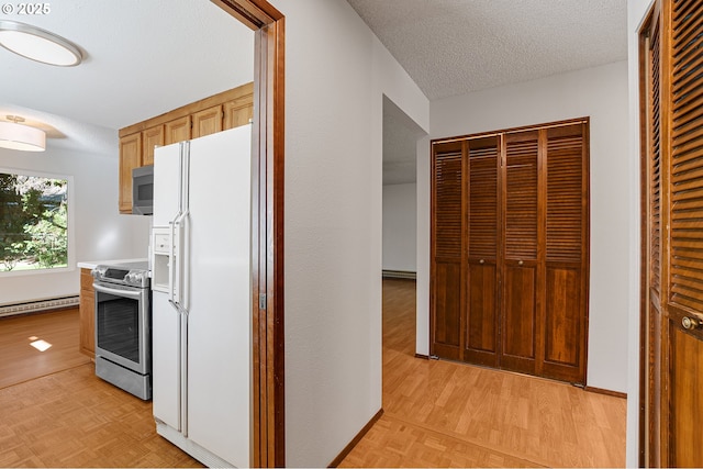 10915 SW Meadowbrook Dr Unit 22, Portland, OR 97224 - kitchen featuring appliances with stainless steel finishes, baseboard heating, light countertops, parquet flooring, and a textured ceiling