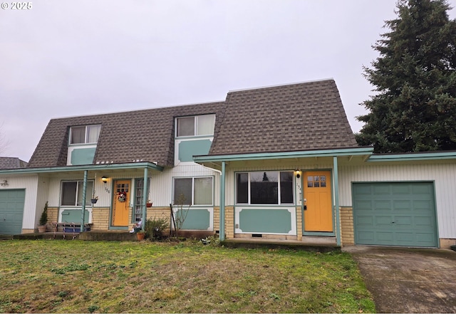 view of front of property with a front yard, a garage, and covered porch