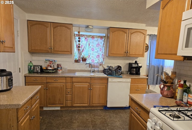 kitchen with sink, white appliances, a textured ceiling, and tasteful backsplash