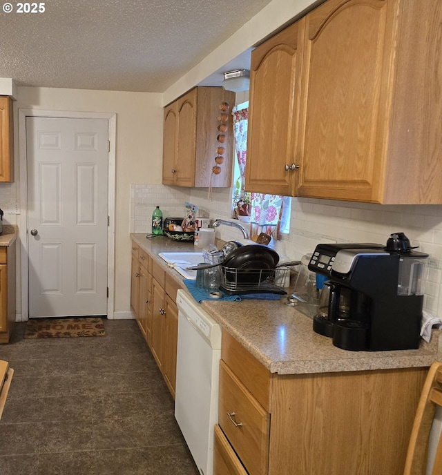 kitchen with sink, backsplash, a textured ceiling, and dishwasher