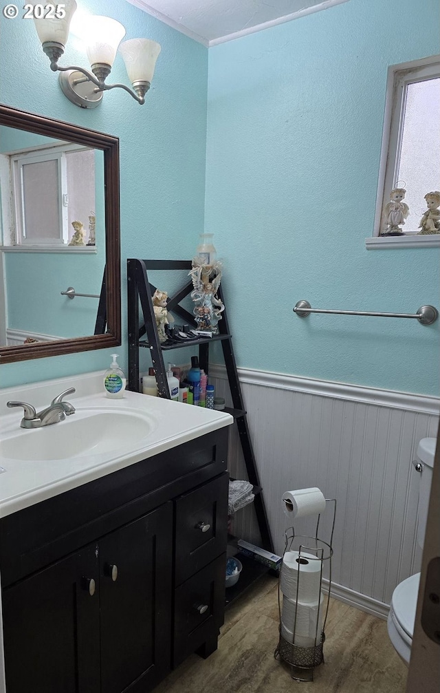 bathroom featuring toilet, vanity, hardwood / wood-style floors, and a notable chandelier