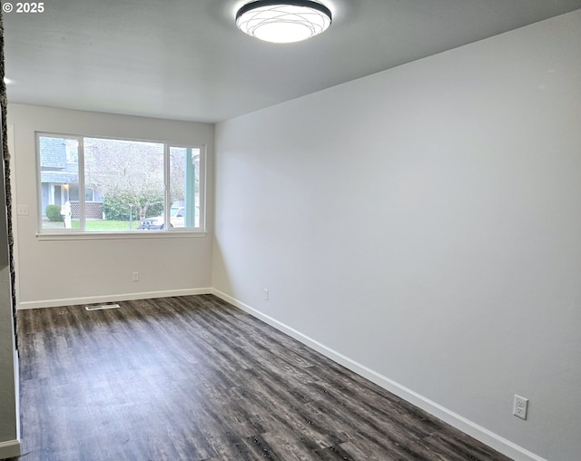 spare room with dark wood-type flooring