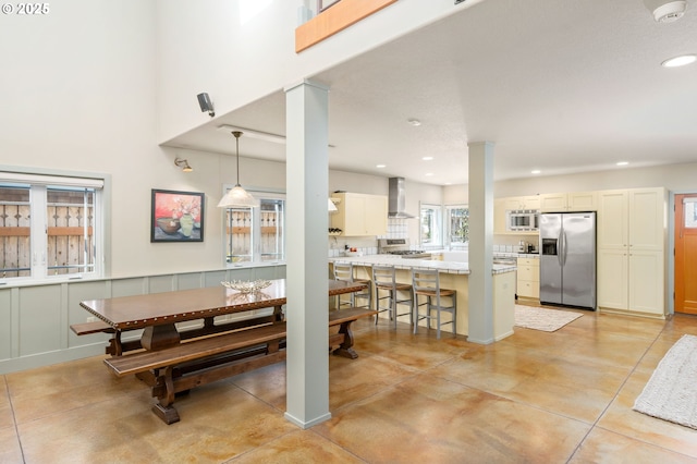 dining area featuring ornate columns, recessed lighting, and a towering ceiling