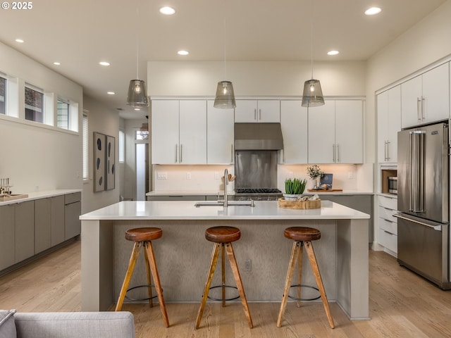 3770 NE 7th Ave, Portland, OR 97212 - kitchen with high end refrigerator, a sink, under cabinet range hood, modern cabinets, and recessed lighting