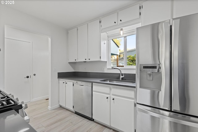 kitchen with dishwasher, sink, stainless steel refrigerator with ice dispenser, white cabinets, and light wood-type flooring