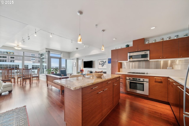 kitchen with brown cabinets, dark wood-type flooring, and appliances with stainless steel finishes