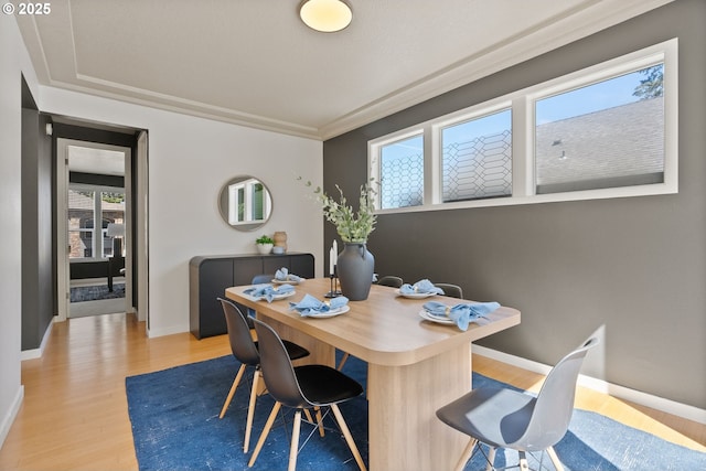 dining area featuring light wood-style flooring, baseboards, and a desk