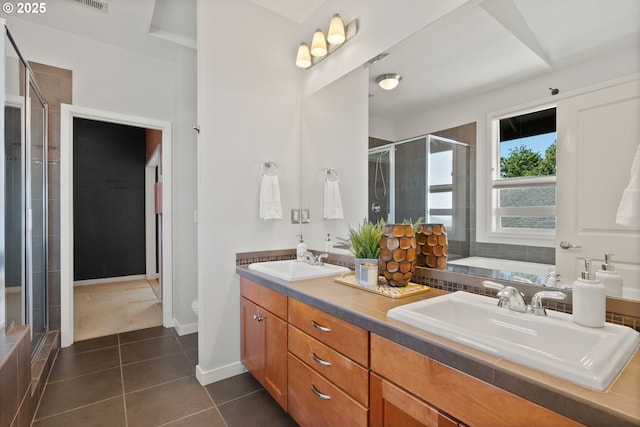 full bath featuring a stall shower, tile patterned floors, double vanity, toilet, and baseboards