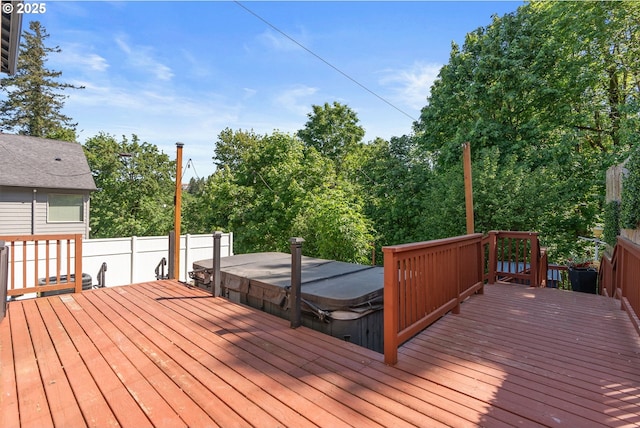wooden terrace featuring a covered hot tub and view of scattered trees