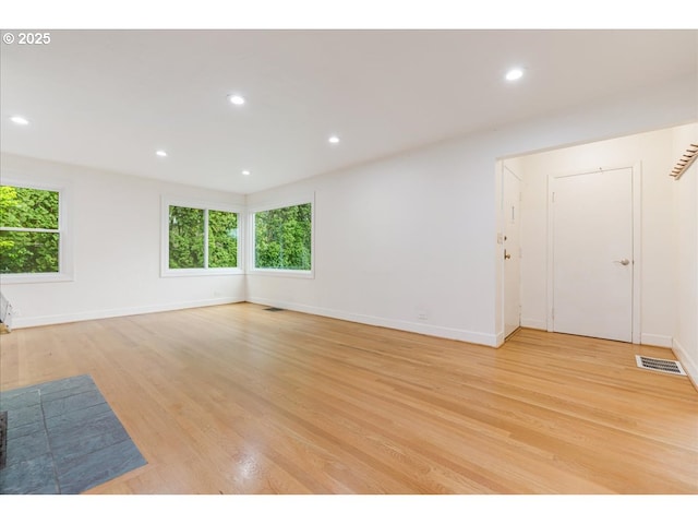 unfurnished living room with visible vents, recessed lighting, light wood finished floors, and baseboards