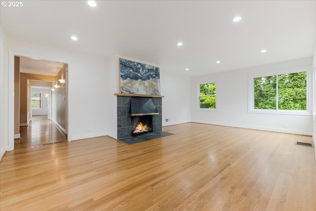 3400 SW 110th Ave, Beaverton, OR 97005 - unfurnished living room featuring visible vents, a tiled fireplace, baseboards, light wood-style floors, and recessed lighting