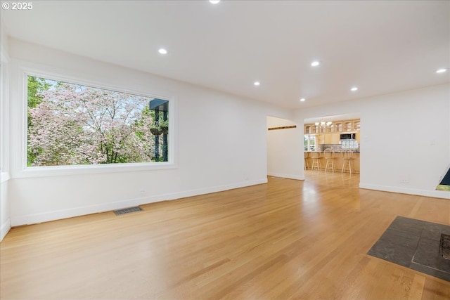 3400 SW 110th Ave, Beaverton, OR 97005 - unfurnished living room with baseboards, a wealth of natural light, light wood-style flooring, and visible vents