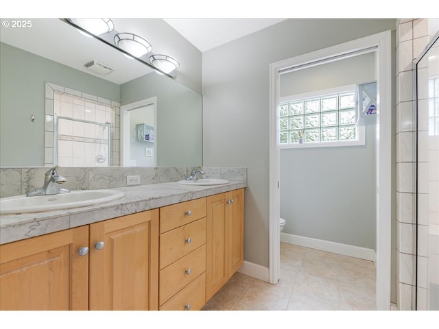 bathroom with a sink, tile patterned flooring, double vanity, and visible vents