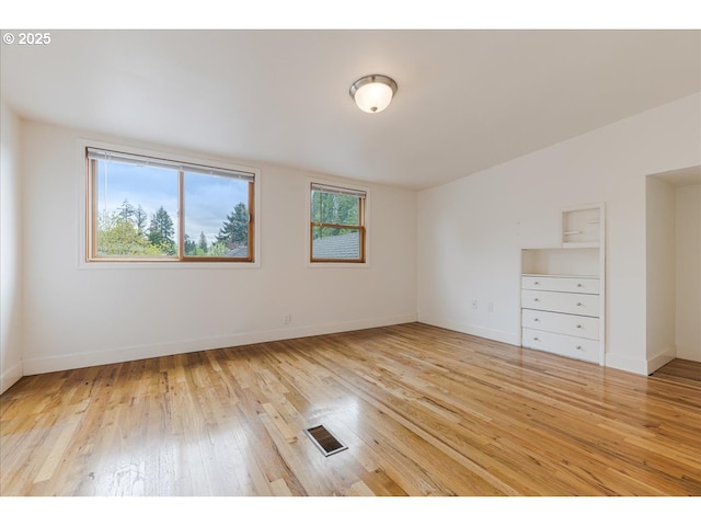 empty room with baseboards, visible vents, and light wood-style flooring