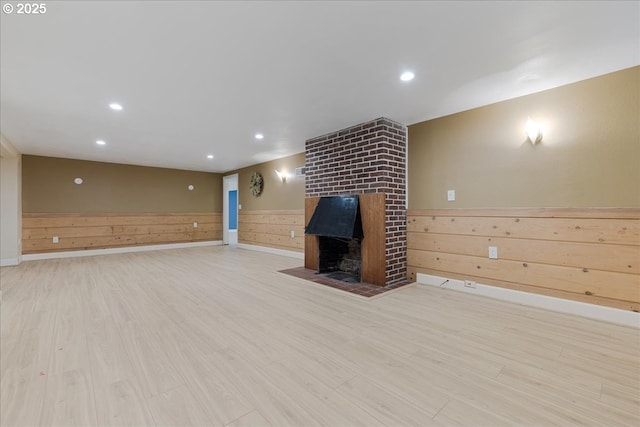 3400 SW 110th Ave, Beaverton, OR 97005 - unfurnished living room with wooden walls, wainscoting, a fireplace, recessed lighting, and light wood-type flooring