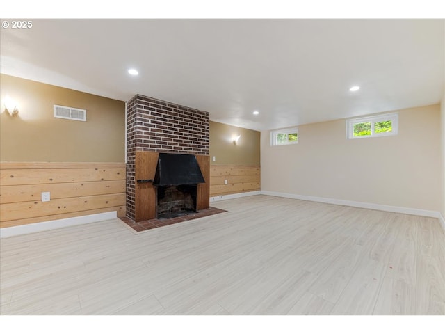 basement with a fireplace, recessed lighting, baseboards, wood finished floors, and visible vents