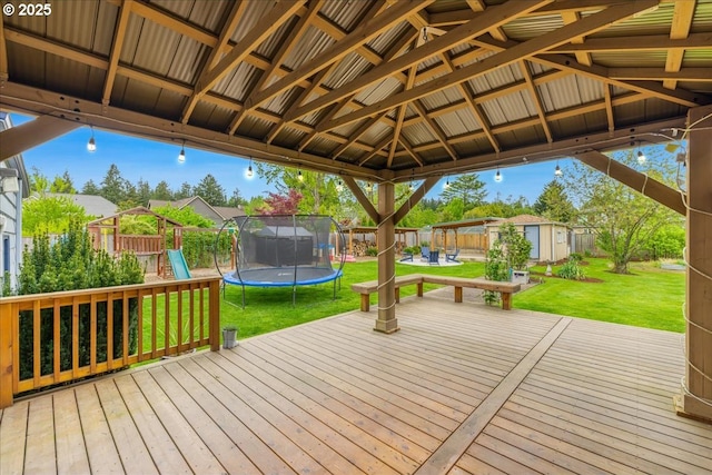 3400 SW 110th Ave, Beaverton, OR 97005 - deck with a storage unit, a playground, a lawn, a trampoline, and an outbuilding