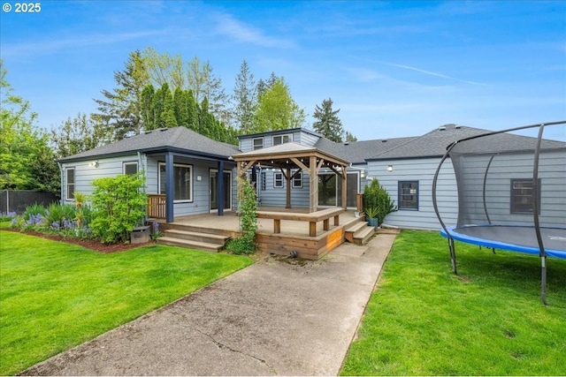 3400 SW 110th Ave, Beaverton, OR 97005 - back of property featuring a lawn, a gazebo, a shingled roof, and a trampoline