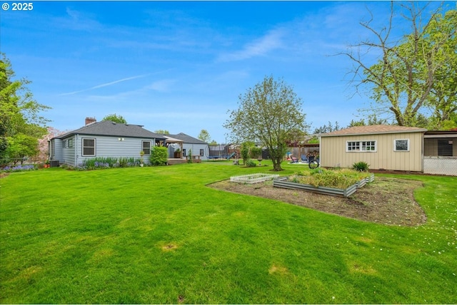 view of yard with fence and a vegetable garden